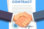 Business man shaking hands over a signed contract