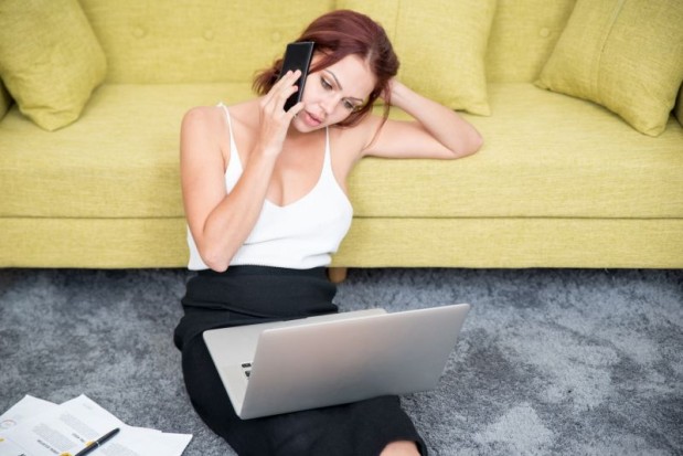 Confident businesswoman talking on phone at home